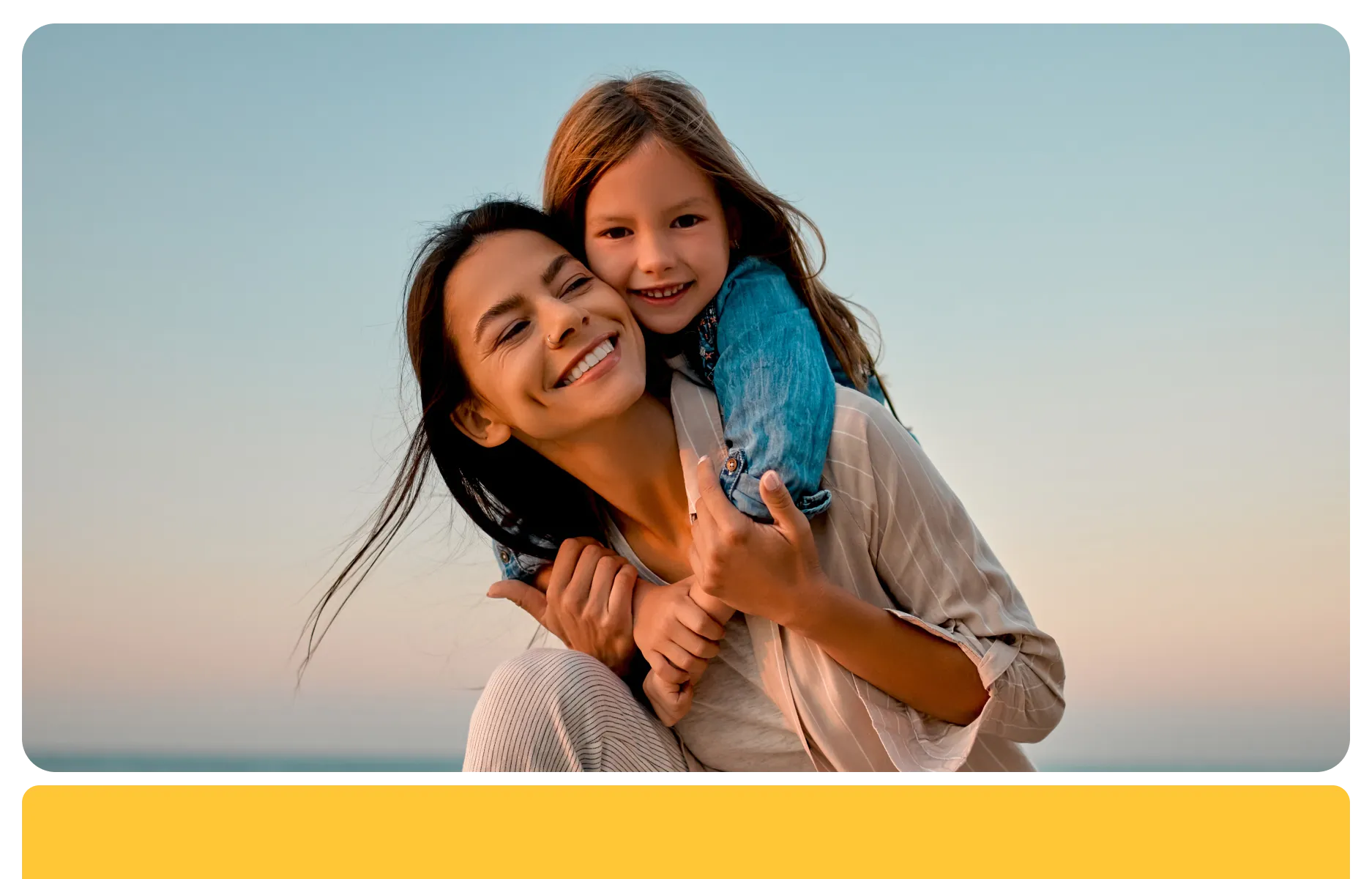 Woman carrying child on back and both smiling
